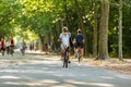 A young blond woman and man cyclingÃÂ in a sunny and green Amsterdam Vondelpark